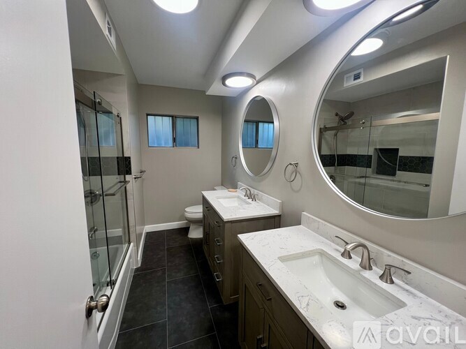 A bathroom with a sink, mirror, and toilet.