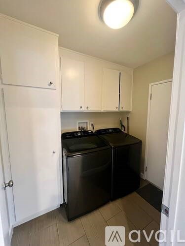A small kitchen with black appliances and white cabinets.