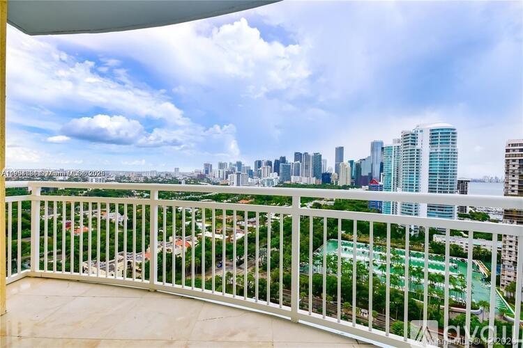 A balcony overlooks a cityscape with a mix of residential and commercial buildings.