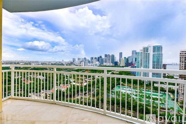 A balcony overlooks a cityscape with a mix of residential and commercial buildings.