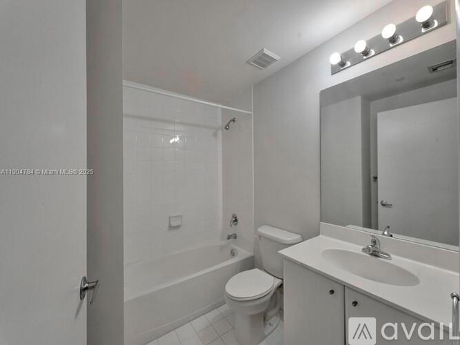 A bathroom with a toilet, sink, and mirror.