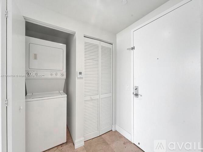 A white fridge and freezer in a small room with a closed door.