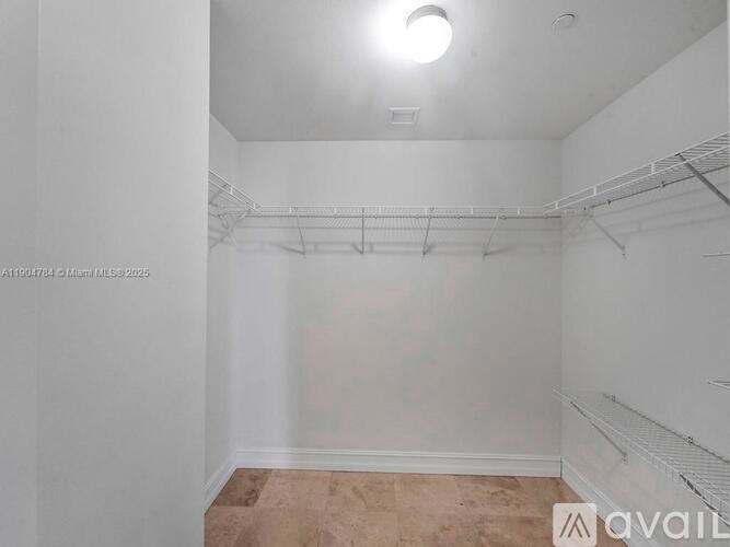 A white empty room with a carpeted floor and a ceiling light.