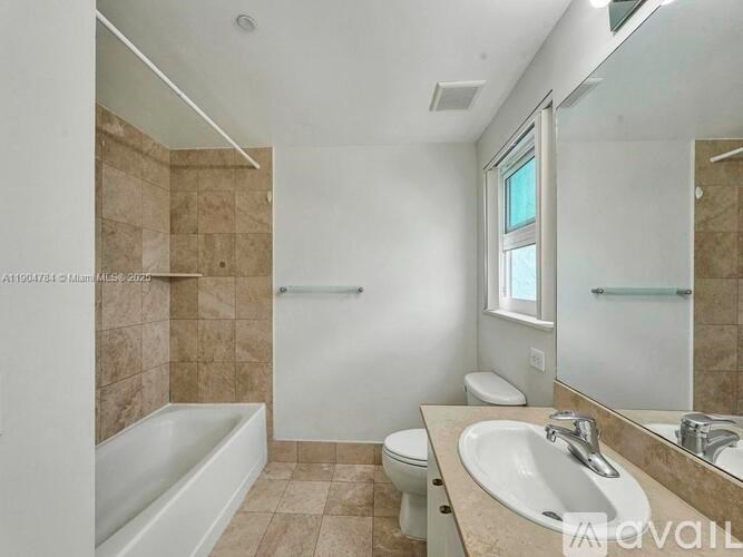 A bathroom with a tub, toilet, and sink.