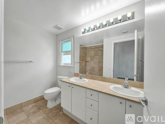 A bathroom with a toilet, sink, and mirror.