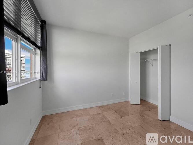 A room with a tiled floor and a window with blinds.