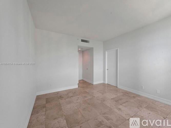 A room with a tiled floor and two doors.