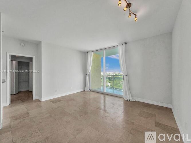 A room with a sliding glass door leading to a balcony.