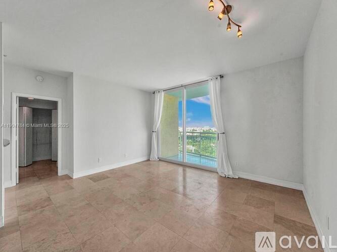 A room with a sliding glass door leading to a balcony.