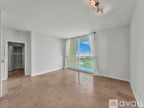 A room with a sliding glass door leading to a balcony.