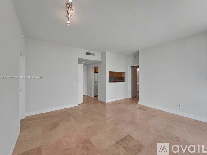 A spacious room with tiled flooring and white walls.