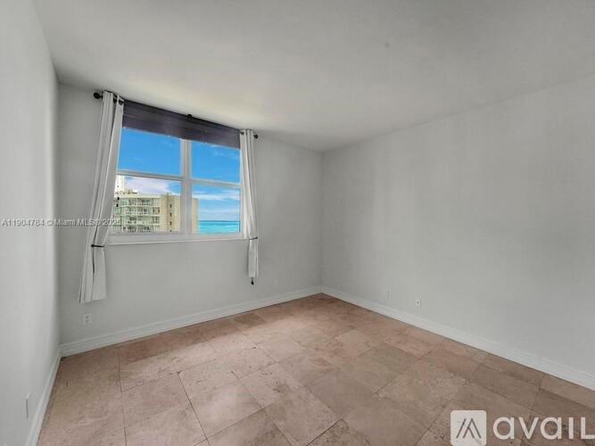 A room with a large window and a view of a building outside.