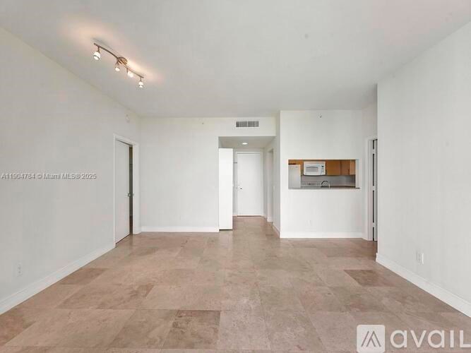 A spacious room with a tiled floor and white walls.