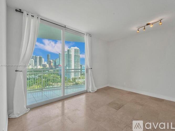 A room with a large window overlooking a cityscape.
