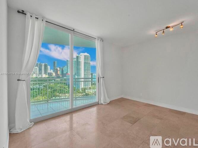 A room with a large window overlooking a cityscape.