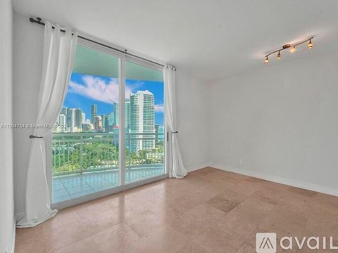 A room with a large window overlooking a cityscape.