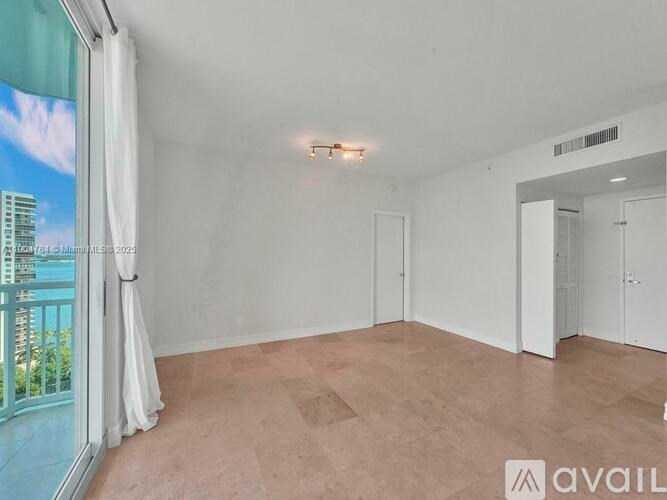 A spacious room with a large window overlooking a cityscape.