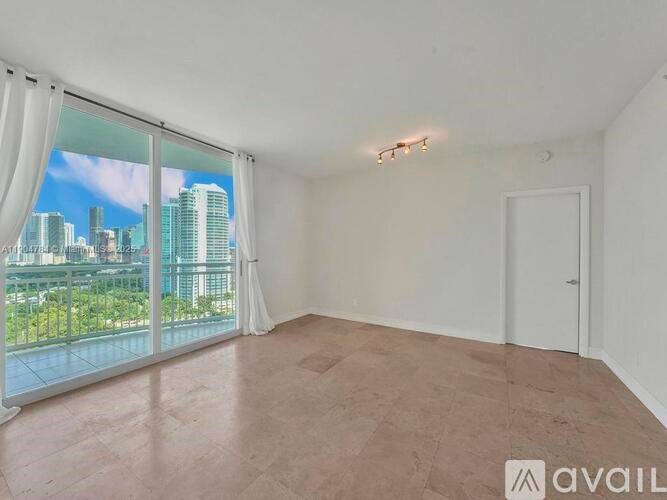 A room with a view of the city through a large window.