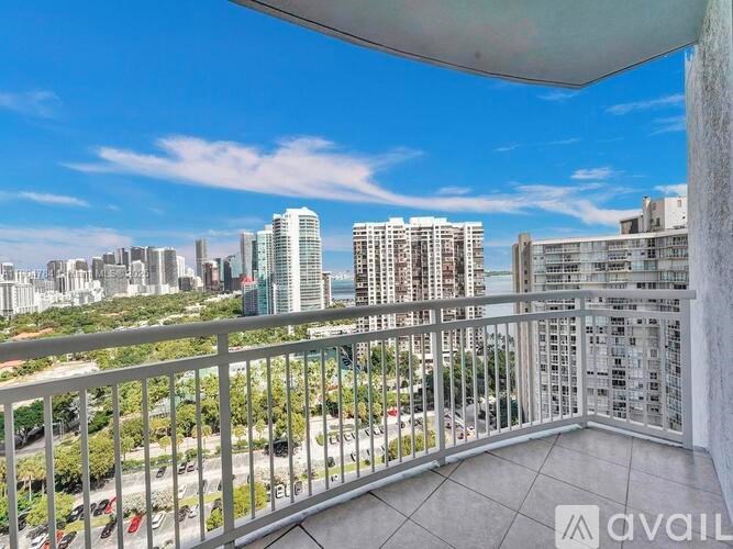 A balcony with a metal railing overlooks a cityscape.