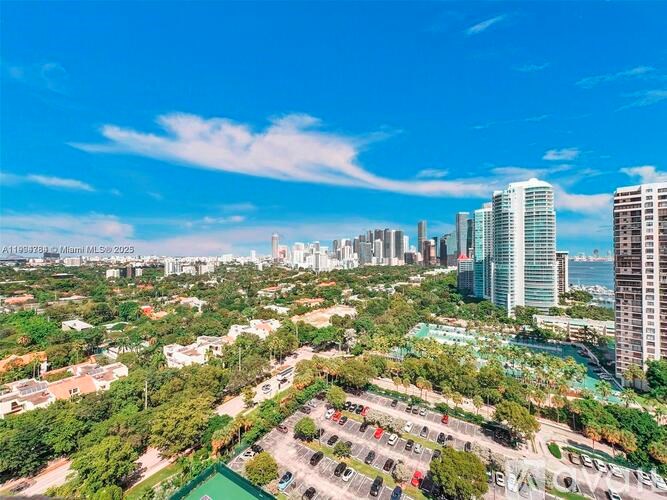 A cityscape with a clear blue sky and a mix of residential and commercial buildings.
