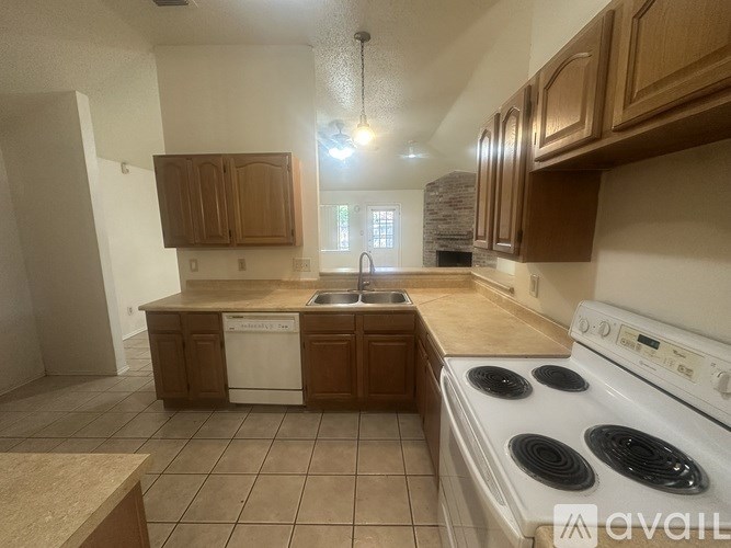 A kitchen with a white stove top oven and brown cabinets.