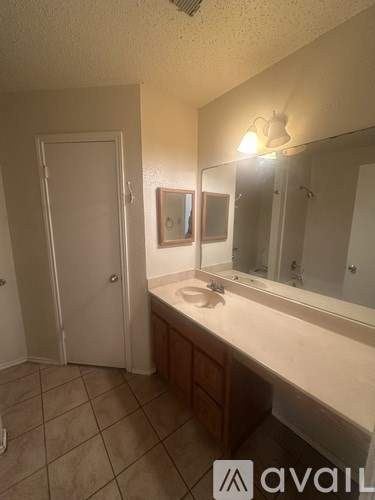 A bathroom with a sink, mirror, and a white door.