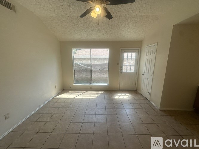 A room with a ceiling fan and tiled flooring.