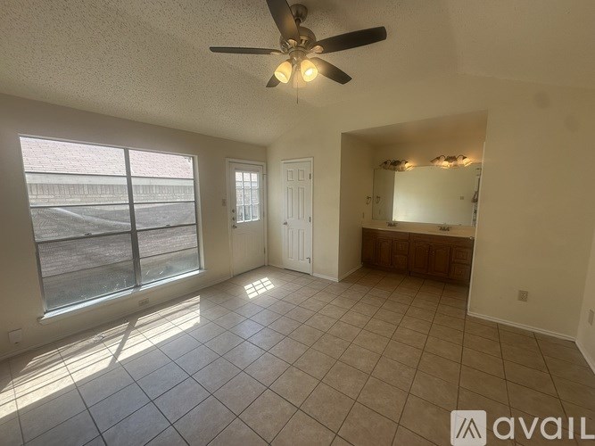 A room with a ceiling fan and tiled flooring.