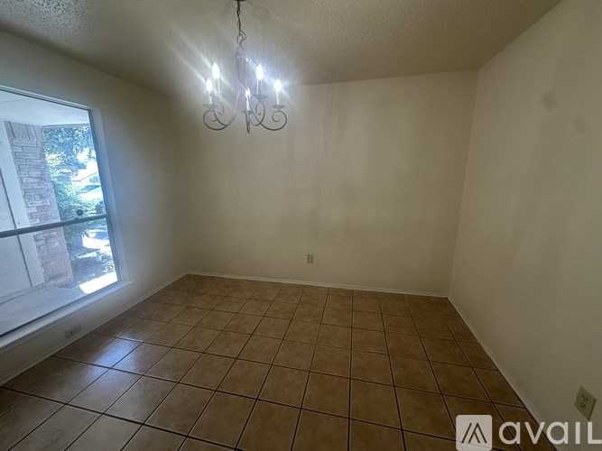 Empty room with tiled floor and a chandelier.