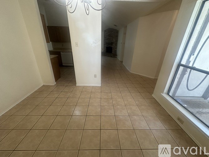 A room with tiled flooring and a large window.