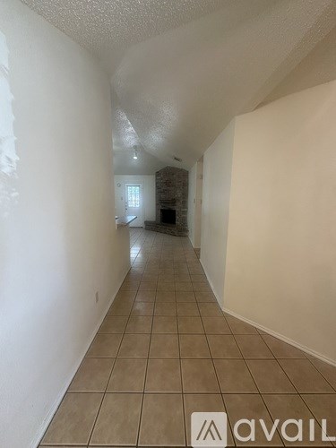 A long hallway with tiled flooring and white walls.
