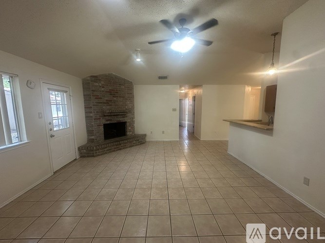A living room with a fireplace and a fan on the ceiling.