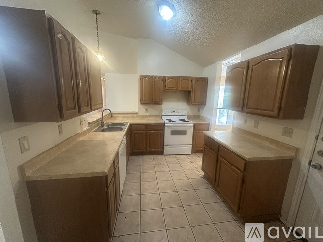 A kitchen with brown cabinets and a white stove top oven.