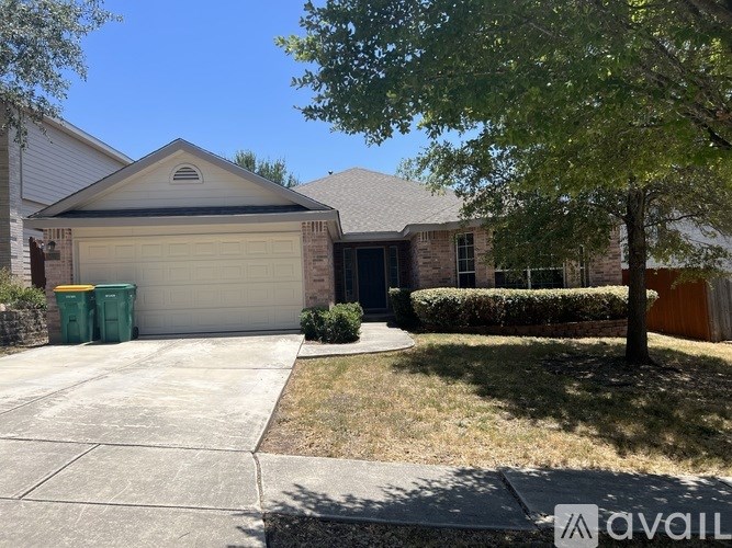 A house with a garage and a tree in front.