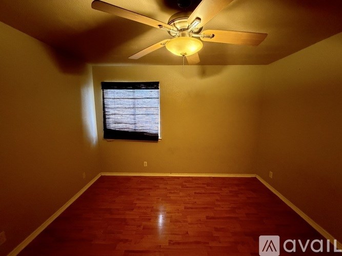A room with a ceiling fan and a window.