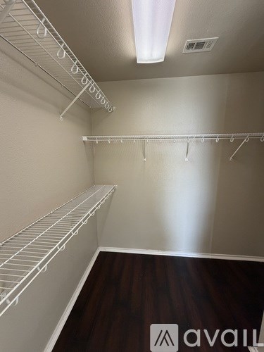 Empty white shelves in a room with wood flooring.