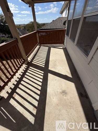 A sunny day on a wooden deck with a white railing.