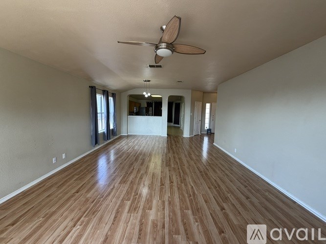 A room with wooden flooring and a ceiling fan.