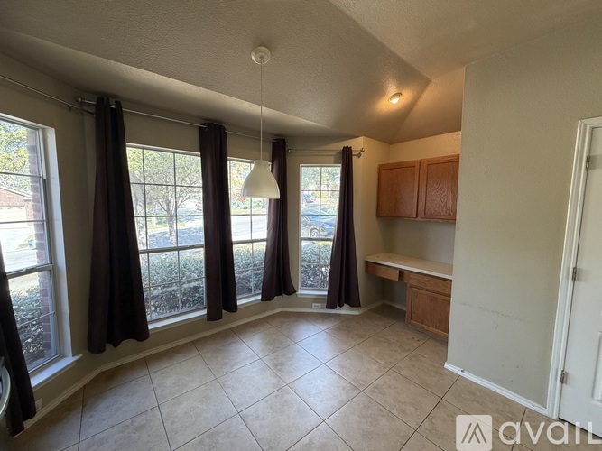 A living room with a large window and curtains.