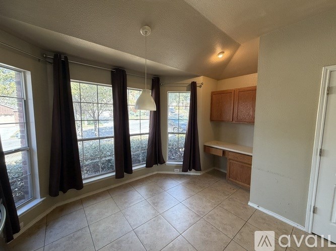 A living room with a large window and curtains.