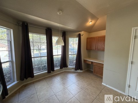 A living room with a large window and curtains.