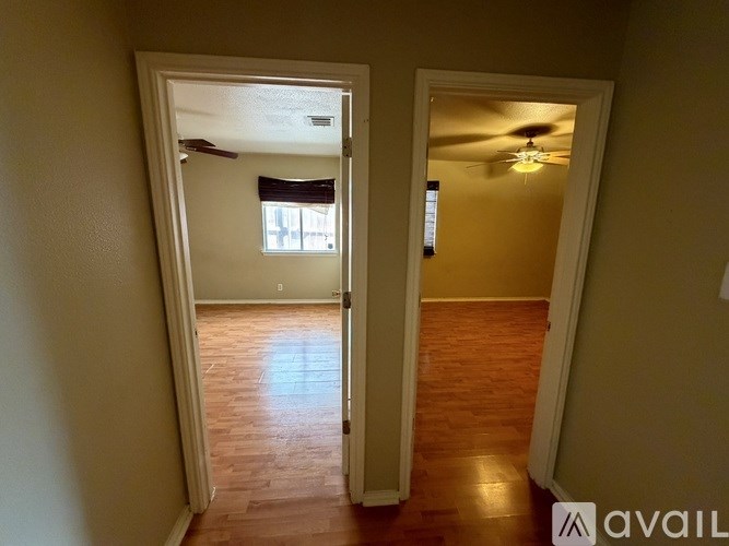 A room with a wooden floor and a ceiling fan.
