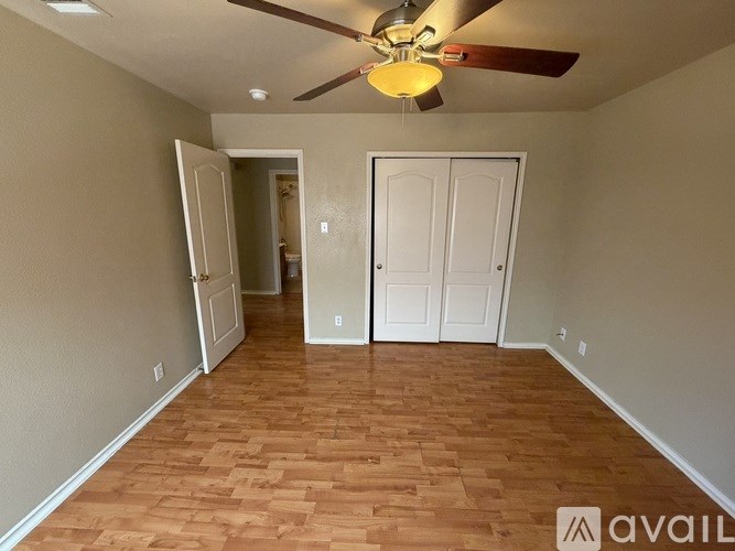 A room with wooden flooring and a ceiling fan.
