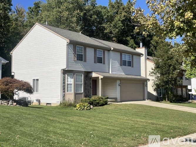 A two-story house with a garage and a driveway.