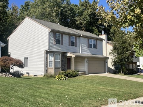 A two-story house with a garage and a driveway.