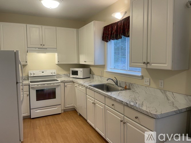 A kitchen with white appliances and cabinets.