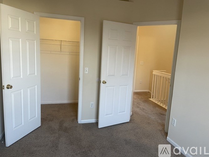 A room with two white doors and a carpeted floor.