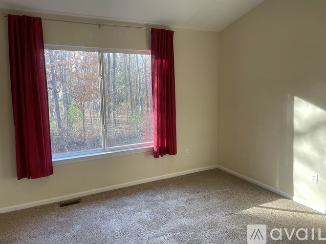 A room with a window and red curtains.