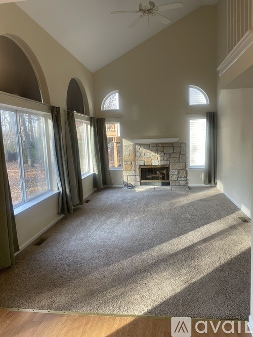 A living room with a carpet floor and a fireplace.