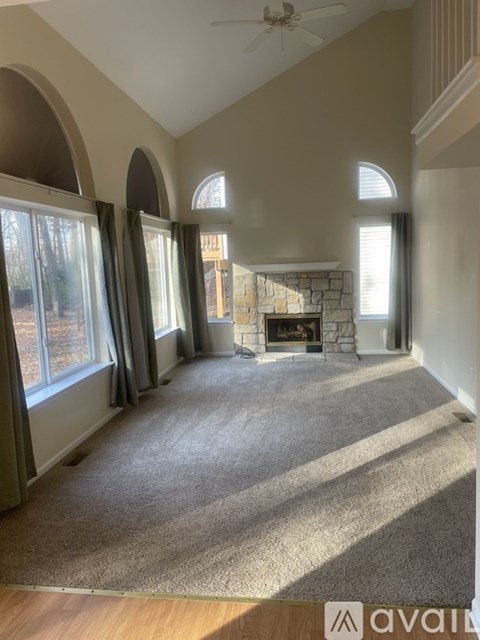 A living room with a carpet floor and a fireplace.